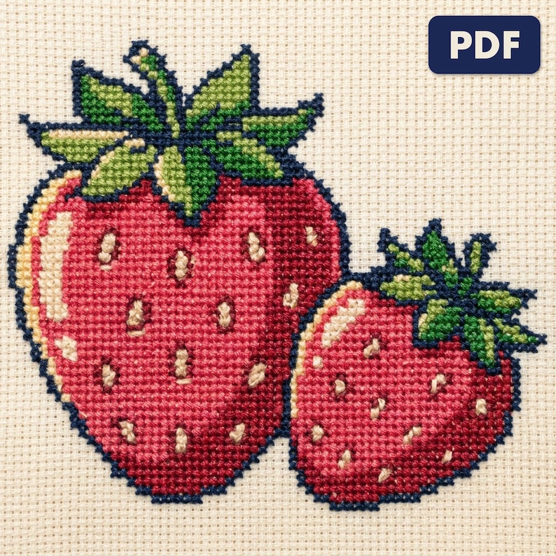 A finished strawberries cross stitch piece, stitched and framed on a wall