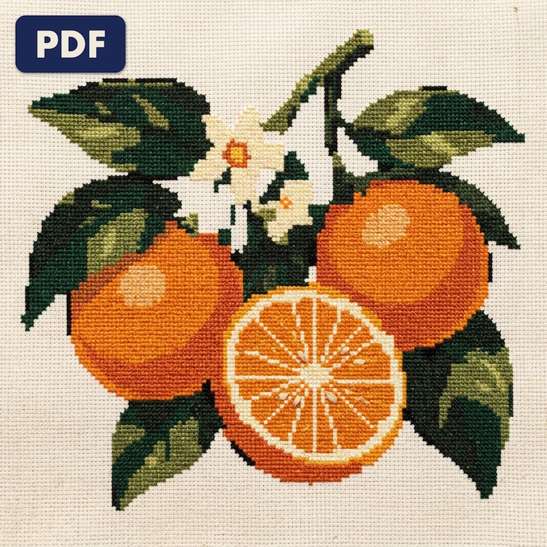 A finished an orange branch cross stitch piece, stitched and framed on a wall
