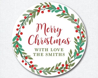 May include: A white round sticker with a green and red holly wreath border. The text "Merry Christmas" is in red and the text "With Love The Smiths" is in black.