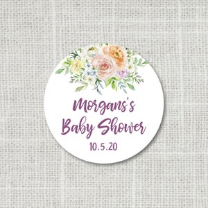Peut inclure: Autocollant rond blanc avec un motif floral aquarelle dans des tons de rose, p&ecirc;che, jaune et bleu. Le texte "Morgan's Baby Shower 10.5.20" est imprim&eacute; en violet.