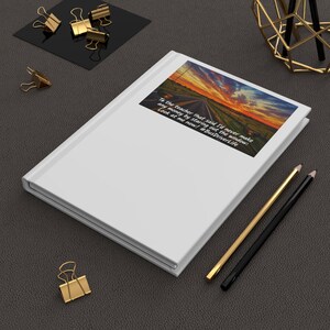 May include: A white hardcover notebook featuring a rectangular graphic on the cover. The graphic depicts a sunset over a road with the text: To the teacher that said I'd never make any money by staring out the window: Look at me now! #BusDriverLife.