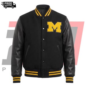 Pode incluir: Um casaco varsity preto com mangas compridas pretas, um emblema amarelo com a letra M no peito esquerdo e gola, punhos e bainha canelados com riscas amarelas. O casaco inclui um fecho frontal com botões de pressão e dois bolsos laterais.