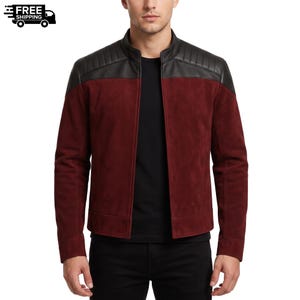 Può includere: Una giacca in camoscio bordeaux con pannello superiore in pelle nera, dettagli trapuntati sulle spalle, colletto alla coreana e chiusura frontale con zip. La giacca è indossata sopra una maglietta nera tinta unita e pantaloni neri.