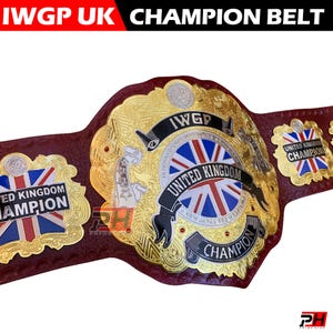 Può includere: Una cintura da campionato con cinturino in pelle rosso scuro e placche metalliche dorate decorate. La placca centrale mostra una bandiera Union Jack, il testo IWGP, UNITED KINGDOM e CHAMPION, con placche laterali che riportano la bandiera.
