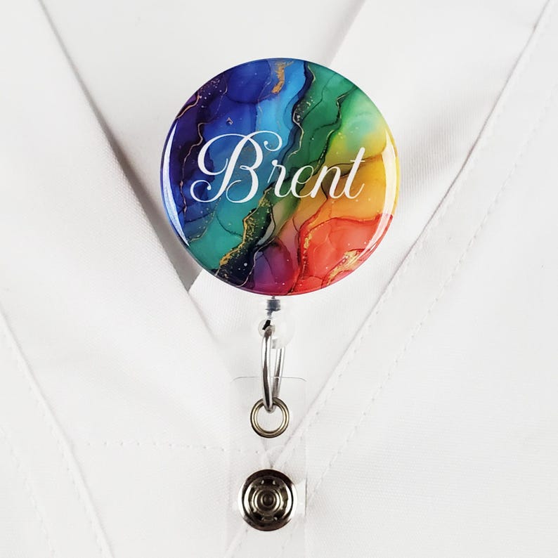 Puede incluir: Un carrete de credencial colorido con un dise&ntilde;o abstracto de arco&iacute;ris y el nombre "Brent" en letras blancas.