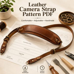 Op de afbeelding: Een bruine lederen camerariem met messing hardware, inclusief schouderstuk en verstelbare gespen, liggend op een papieren patroon. De tekst luidt Leather Camera Strap Pattern PDF, Comfortable, Adjustable, Handmade, Digital Download en Instant Access.