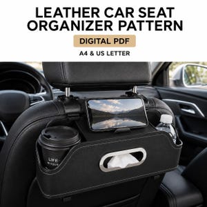 Puede incluir: Un patrón PDF digital para un organizador de asiento de coche de cuero, compatible con papel A4 y US Letter. El organizador es negro, cuenta con un portavasos, un soporte para smartphone y una ranura para una caja de pañuelos.