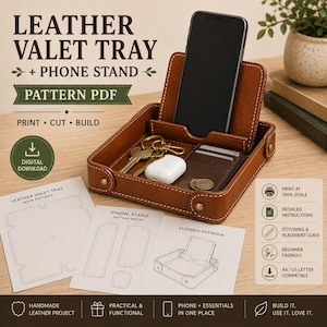 Può includere: Un vassoio svuotatasche in pelle marrone con supporto per telefono integrato, contenente uno smartphone, chiavi, auricolari wireless e un portacarte. L'immagine include fogli di cartamodello PDF stampati con il testo: LEATHER VALET TRAY + PHONE STAND.