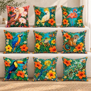 May include: A set of nine square throw pillows featuring vibrant tropical designs. Each pillow displays a different animal, including an owl, cockatoo, flamingo, macaw, frog, monkey, toucan, parakeet, and chameleon, surrounded by hibiscus flowers.