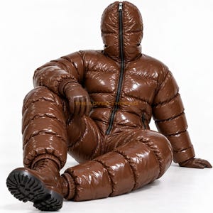 May include: A glossy brown full-body puffer suit featuring a hood that zips up to the top, long sleeves, and matching brown gloves. The suit has a quilted, insulated design with a black zip running down the centre. The text THELOVEDTHREAD is visible.