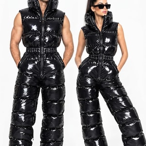 May include: Two matching black sleeveless jumpsuits made of a shiny, high-gloss, quilted puffer material. Each jumpsuit features a high collar, a full-length front zipper, an elasticized waist, and wide-leg trousers with horizontal quilted sections.