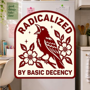 May include: A cream-colored sticker with a dark red border and design. It features a bird perched on a branch surrounded by flowers and stars. The text RADICALIZED is arched above the bird, and BY BASIC DECENCY is printed below the bird.