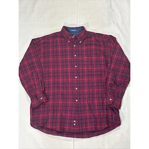 May include: A long-sleeve button-down shirt featuring a dark red and navy blue plaid pattern. The shirt has a button-down collar, a front button placket with light-colored buttons, and buttoned cuffs. The fabric has a visible textured weave.