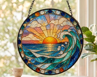 Könnte beinhalten: Ein kreisförmiger Buntglas-Sonnenfänger mit einem lebendigen Sonnenuntergang über dem Ozean und einer großen, brechenden Welle im Vordergrund. Das Stück ist in einen dunklen Metallrahmen gefasst, hängt an einer schwarzen Kette und zeigt Blau-, Türkis-, Orange- und Gelbtöne.