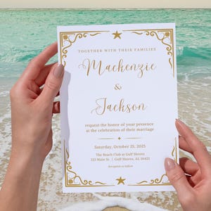 May include: A white wedding invitation with gold decorative borders and text. The invitation reads "Mackenzie & Jackson" and includes event details. The background shows a beach scene with the ocean and sand.