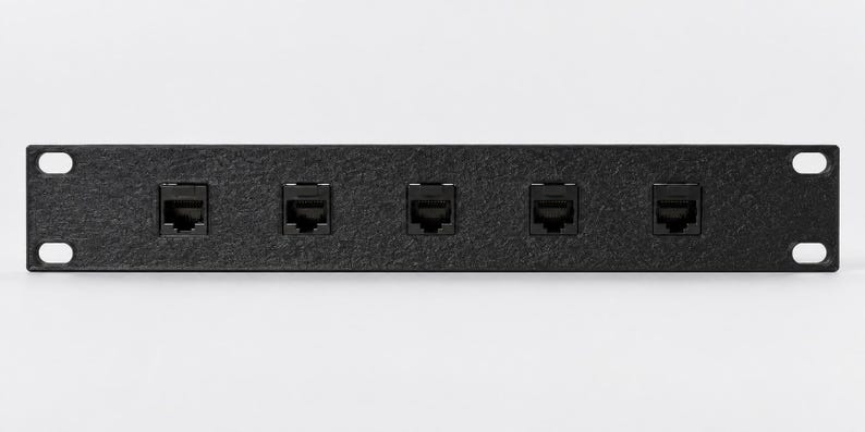 Pode incluir: Um painel de conex&atilde;o preto para montagem em rack com acabamento texturizado e cinco portas Ethernet RJ45 dispostas horizontalmente. O painel met&aacute;lico retangular inclui quatro orif&iacute;cios de montagem, um em cada canto, para instala&ccedil;&atilde;o.