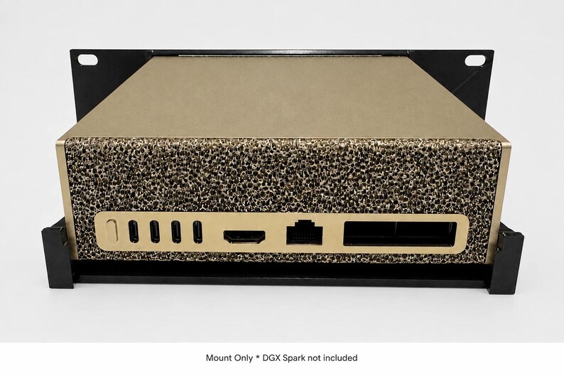 May include: A black metal rack mount holding a gold-colored electronic device with a textured front panel. The device features multiple ports including USB-C, HDMI, and Ethernet. Text at the bottom reads: Mount Only * DGX Spark not included.