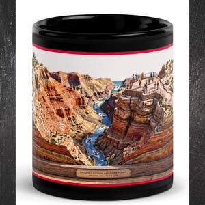 Może przedstawiać: Czarny ceramiczny kubek z panoramicznym nadrukiem Wielkiego Kanionu w Mather Point w Arizonie. Obraz przedstawia warstwowe formacje skalne, wijącą się niebieską rzekę z małymi łodziami oraz platformę widokową. Tekst: GRAND CANYON - MATHER POINT, ARIZONA, USA | SCALE 1:250.