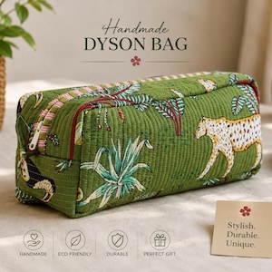 May include: A rectangular quilted bag in a green fabric featuring a printed pattern of leopards and tropical plants. The bag has a zippered closure with a white pull tab and a red trim. Text on the bag reads Handmade DYSON BAG.