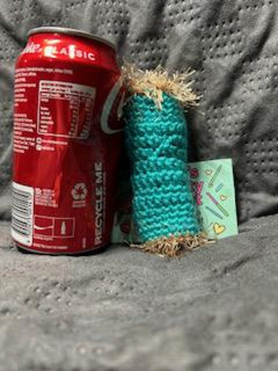 A hand-crocheted willy warmer with fluffy trim — the kind of absurd, genuinely handmade gag gift that makes a white elephant party erupt.