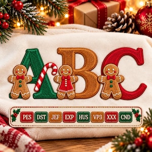 May include: An embroidered design on cream fabric featuring the letters A, B, and C in green, brown, and red. Three gingerbread figures are positioned in front of the letters, with a candy cane near the A. A rectangular label lists PES, DST, JEF, EXP, HUS, VP3, XXX, and CND.