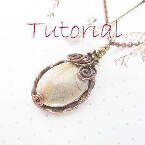 May include: A copper wire wrapped pendant with a beige stone and a copper and brass swirl design. The pendant is attached to a copper chain.