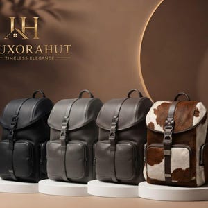 May include: Four backpacks arranged in a row, featuring a flap-top design with a central buckle strap and a front pocket. The first is black, the second is dark gray, the third is brown, and the fourth has a brown and white cowhide pattern.