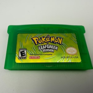 May include: A translucent green Game Boy Advance video game cartridge for Pok&eacute;mon LeafGreen Version. The label features the Pok&eacute;mon logo, the text LeafGreen Version, an ESRB E rating, the Nintendo logo, and the product code AGB-BPGE-USA.