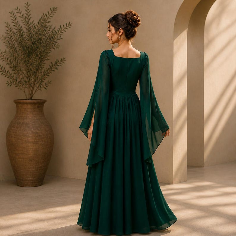 May include: A floor-length dark emerald green dress featuring long, flowing bell sleeves and a square neckline. The garment has a fitted bodice that transitions into a full, pleated skirt, showcasing a solid color and a lightweight, sheer fabric.