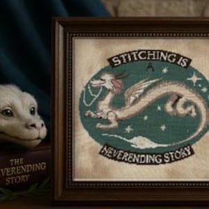 Puede incluir: Imagen de punto de cruz enmarcado con un diseño de dragón y el texto "Stitching is a Neverending Story". La paleta de colores incluye tonos turquesa, beige y marrón. La imagen también incluye un dragón de peluche y carretes de hilo.