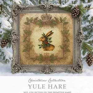 May include: A framed print featuring a brown hare adorned with holly and berries, set against a vintage-style background. The frame is ornate, silver-toned, and decorated with pinecones and greenery. Text at the bottom reads "Yule Hare" and "Christmas Collection".