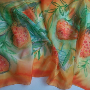May include: A silk scarf with a watercolor design of orange and red fruits with green leaves on a yellow and orange background.