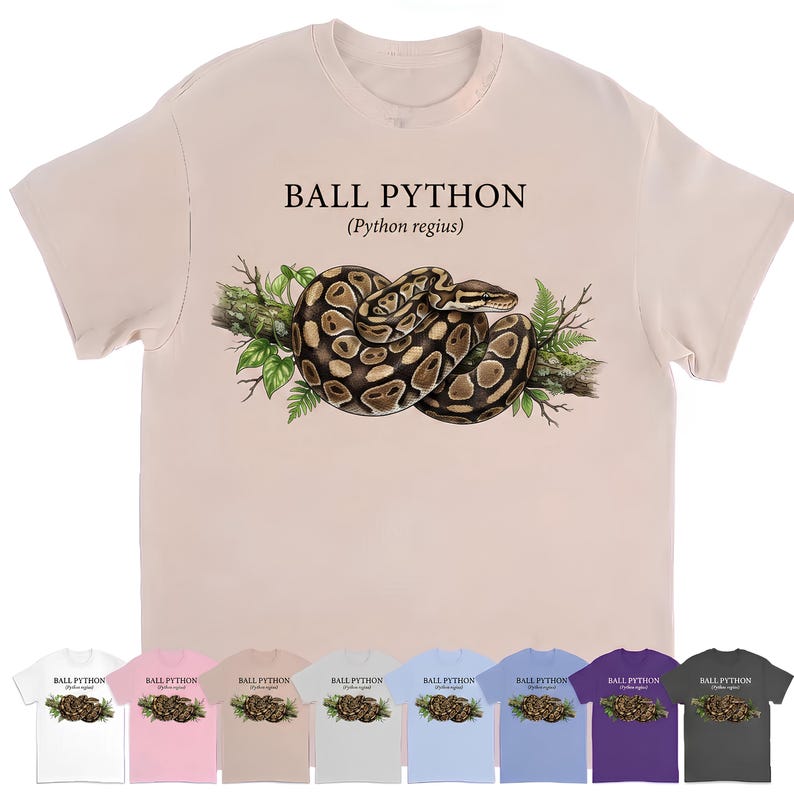 Pu&ograve; includere: Una t-shirt beige chiaro con un'illustrazione grafica di un pitone reale avvolto su un ramo con foglie verdi. Il testo "BALL PYTHON (Python regius)" &egrave; stampato in nero sopra l'illustrazione del serpente sul petto della maglietta.
