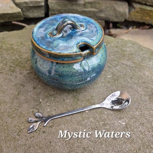 May include: A set of three ceramic mugs with a speckled, matte finish. The mugs are in shades of cream, light gray, and dark gray. Each mug has a simple, minimalist design, perfect for coffee or tea.