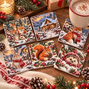 Puede incluir: Un juego de seis posavasos cuadrados con escenas invernales de animales del bosque como ciervos, zorros, erizos, conejos y ardillas, junto a una cabaña nevada, decorados con bayas rojas, ramas de pino y patrones festivos.
