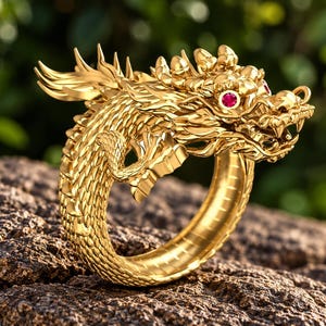 Puede incluir: Un anillo de oro con forma de dragón enroscado con texturas de escamas intrincadas a lo largo de la banda. La cabeza del dragón presenta dos pequeñas piedras preciosas rojas, redondas y vibrantes como ojos, boca abierta y crestas fluidas.