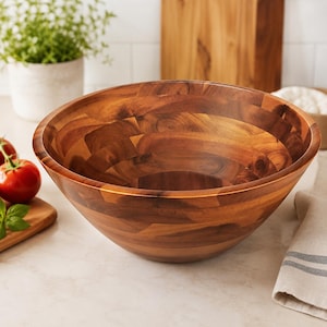 May include: A large, round wooden salad bowl featuring a visible grain pattern with varied brown tones. The bowl is constructed from multiple joined segments of wood, creating a smooth, polished interior and exterior surface with a wide, open rim.