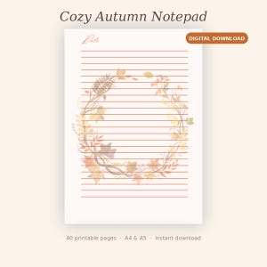 May include: A white notepad page featuring horizontal orange lines and a central wreath illustration composed of autumn leaves and foliage. The text "Cozy Autumn Notepad", "Date:", and "DIGITAL DOWNLOAD" are visible on the page.