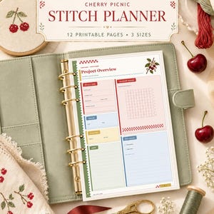 Op de afbeelding: Een saliegroene ringbandplanner met een projectoverzichtspagina met kersenillustraties en de tekst Cherry Picnic Stitch Planner, 12 Printable Pages, 3 Sizes. Inclusief borduurringen, garen en een gouden schaar.