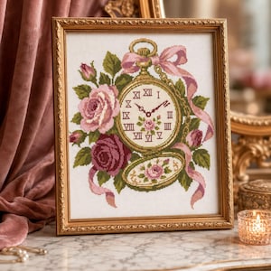 Può includere: Un ricamo a punto croce in una cornice dorata raffigurante un orologio da tasca dorato con numeri romani, circondato da rose rosa e rosso scuro, foglie verdi e un nastro rosa fluente. Il quadrante presenta un piccolo motivo floreale.