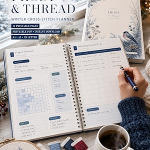 以下が含まれることがあります： Frost & Threadというタイトルのスパイラル綴じクロスステッチプランナーで、プロジェクト概要とステッチセッションログのページがあります。プランナーは白い紙に青いテキストとグリッドセクションが特徴です。ペンがログページに書き込んでいます。近くには青と赤の刺繍糸ボビン3つ、小さな刺繍枠、雪の結晶のデザインが施されたセラミックマグカップがあります。