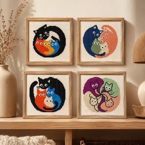 May include: Four square framed cross-stitch artworks featuring circular arrangements of stylized cats. Each piece displays a different color palette, including black, orange, blue, green, purple, and cream, all stitched on a white fabric background.