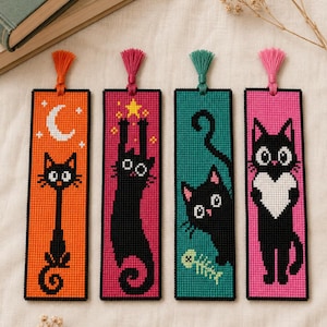 May include: Four rectangular cross-stitch bookmarks featuring black cat designs. The first is orange with a moon, the second is magenta with a cat reaching for a star, the third is teal with a fish skeleton, and the fourth is pink with a heart.
