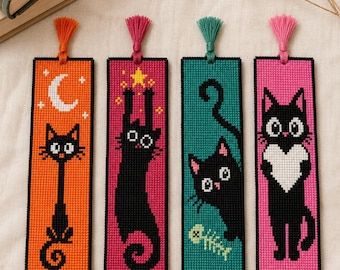 May include: Four rectangular cross-stitch bookmarks featuring black cat designs. The first is orange with a moon, the second is magenta with a cat reaching for a star, the third is teal with a fish skeleton, and the fourth is pink with a heart.