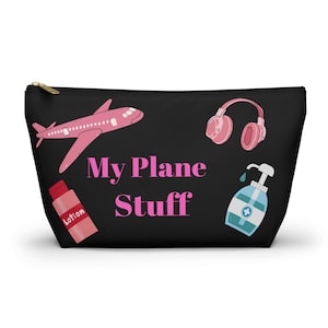 May include: Black zippered travel pouch with pink airplane, pink headphones, blue hand sanitizer bottle, and pink lotion bottle. The text "My Plane Stuff" is printed in pink.