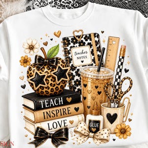 May include: A white sweatshirt featuring a graphic print of a leopard-print apple wearing star-shaped glasses, a notebook labeled teacher notes, a ruler, a pencil, scissors, a glue bottle, and a stack of books with the words TEACH, INSPIRE, LOVE.