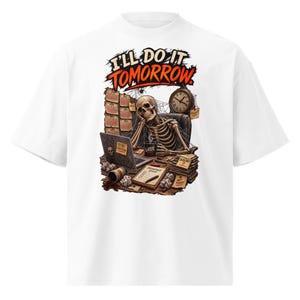 Puede incluir: Una camiseta blanca con un gráfico de un esqueleto sentado en un escritorio con un portátil, un reloj y papeles. El texto dice I'LL DO IT TOMORROW, LATER, IMPORTANT STUFF, DEADLINES y NOT TODAY. La escena incluye telarañas y café.