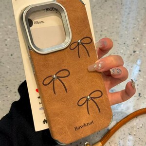 Retro Brown Bow iPhone Case, Faux Suede Phone Cover, Silver Metal Camera Frame, Coquette Wrist Strap Case for iPhone 17 Pro Max 14