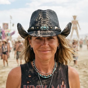 May include: A black and grey snakeskin-patterned cowboy hat featuring a dark leather band adorned with silver-toned studs and a central turquoise-coloured stone inlay. The hat has a curved brim and a textured finish across the crown and brim.
