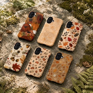 May include: Six rectangular smartphone cases featuring autumn-themed designs. The patterns include orange pumpkins, red and brown fall leaves, acorns, books, and coffee cups on cream, tan, and orange backgrounds. Each case has a black camera cutout.